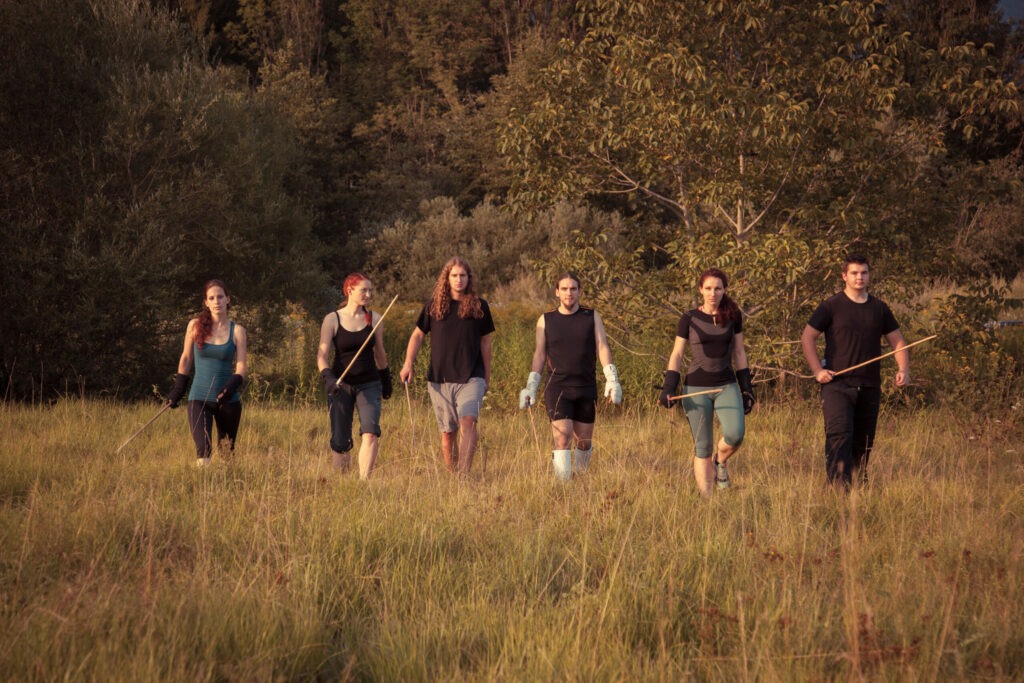 The Canne Klub Kamnik members, stick in hand, walking towards you from across a field